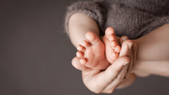 Mother holding babies feet