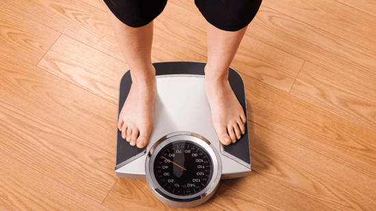 overhead shot of a person standing on a scale to be weighed
