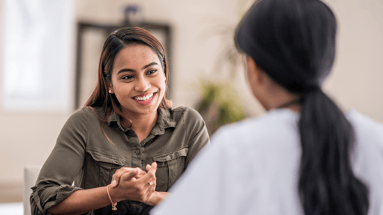 smiling woman sitting across from doctor talking