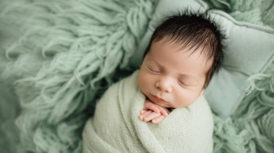 sleeping baby on green blanket