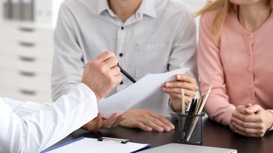 ivf treatment without insurance couple looking at paperwork with doctor