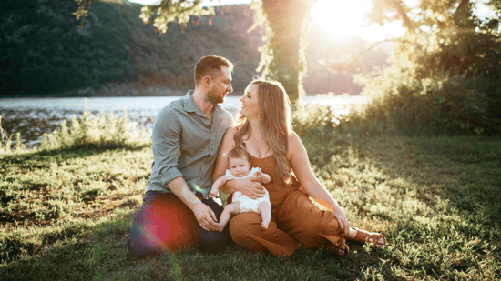 family-holding-baby-outside-on-grass
